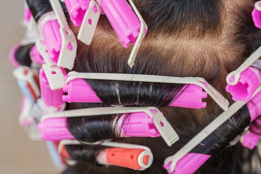 senior woman with hair roller, back