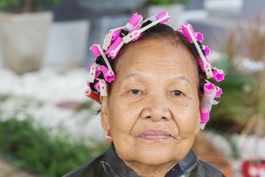 asian senior woman with hair roller