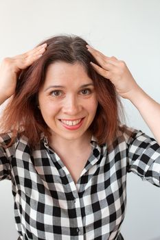 Young woman shows her gray hair roots