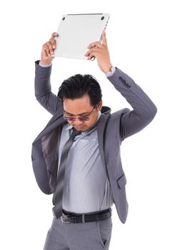 very angry business man is throwing away his laptop isolated on a white background