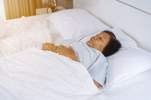 old woman sleeping on a bed in bedroom