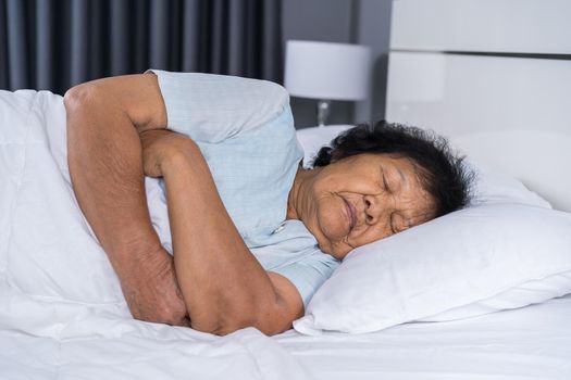 old woman sleeping on a bed in bedroom