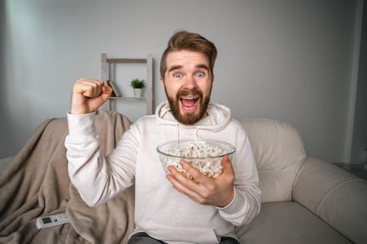 Emotional bearded man watching sport channels on Tv, supporting team at home. Sports fan and championship