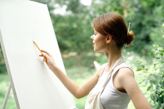 an artist in nature draws on an easel with a pencil. High quality photo