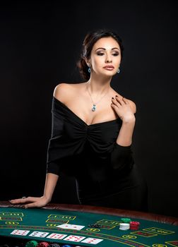 sexy woman with poker cards and chips. Female player in a beautiful black dress