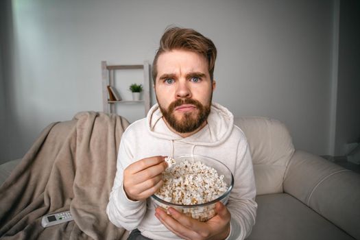 Man watching movies lying on a couch at home