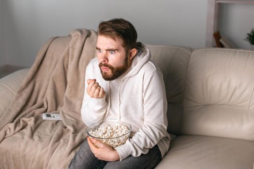 Man watching movies lying on a couch at home