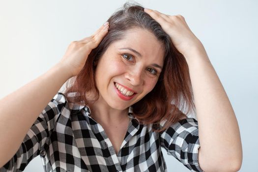 Young woman shows her gray hair roots
