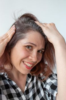 Young woman shows her gray hair roots