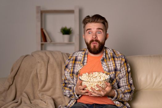single man on the couch watching TV in a room