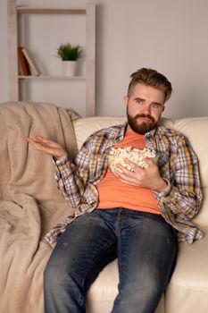 single man on the couch watching TV in a room