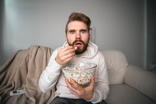 Man watching movies lying on a couch at home