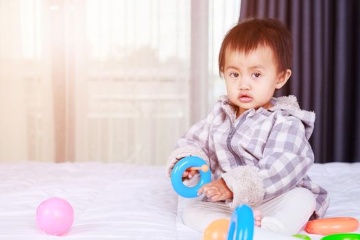 baby playing with toy on bed at home