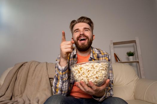single man on the couch watching TV in a room