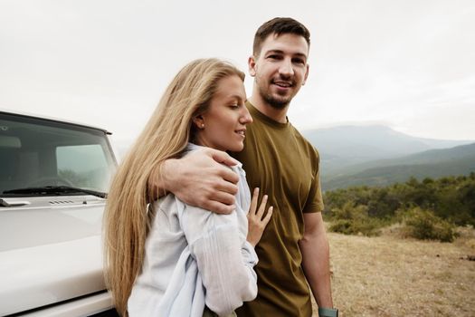 Young couple is on romantic trip to the mountains by car, close up