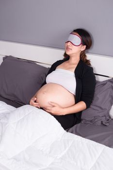 pregnant woman sleeping on bed in the bedroom at home