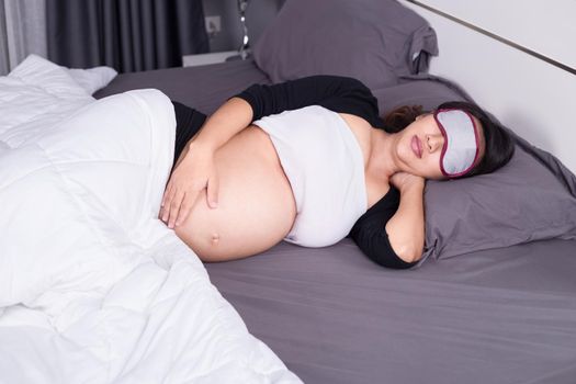 pregnant woman sleeping on bed in the bedroom at home