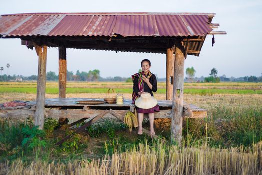 farmer woman sitting in cottage at rice field, Thailand