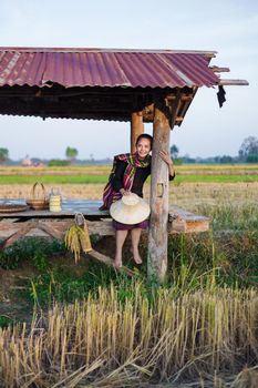 farmer woman sitting in cottage at rice field, Thailand