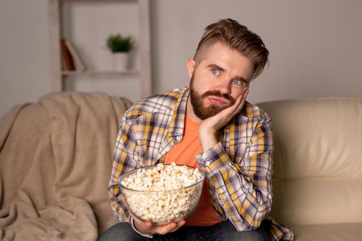 single man on the couch watching TV in a room