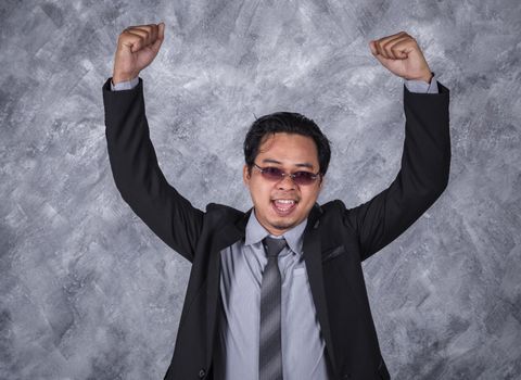 winner young business man in suit with arms raised