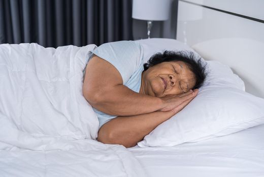 old woman sleeping on a bed in bedroom