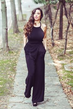 Portrait of pretty girl with long hair wearing black clothes in a park