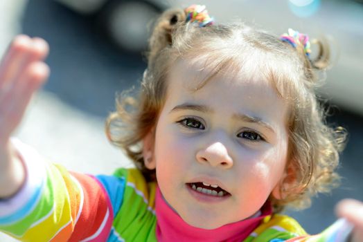 Adorable little girl combed with pigtails outdoors.