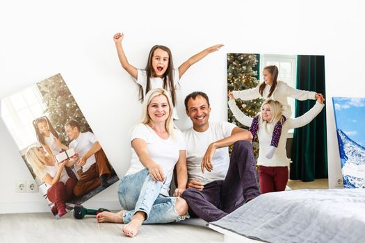 Smiling family holding photo canvas.