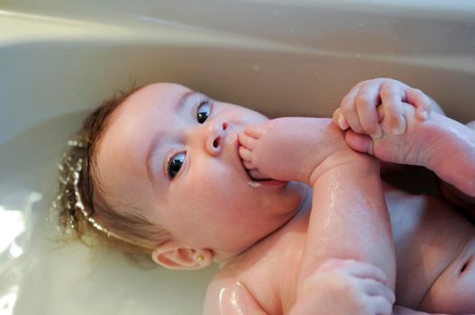 Baby girl four months old having her bath and crying