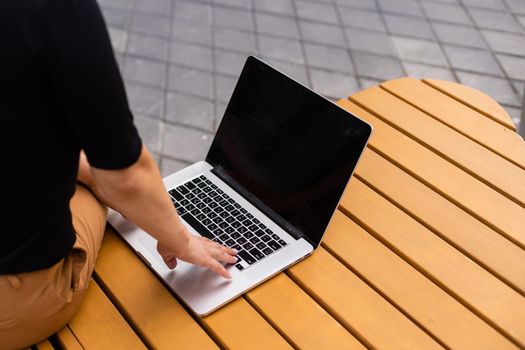Young woman with laptop outside.