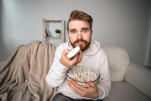 Man watching movies lying on a couch at home