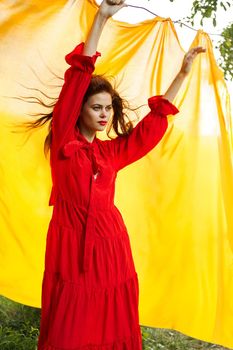 festively outdoors yellow cloth on the background of posing red dress. High quality photo