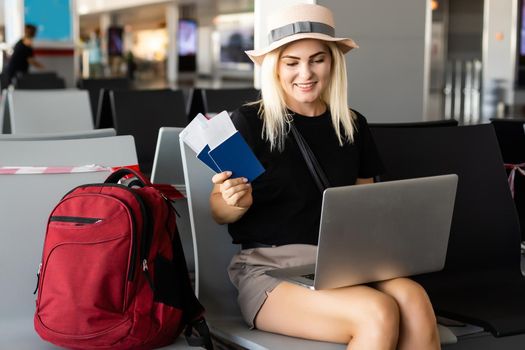 young woman using laptop computer at airport.