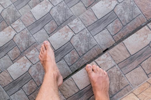 The guy's bare feet go down the stairs. Legs step down, the concept of walking.