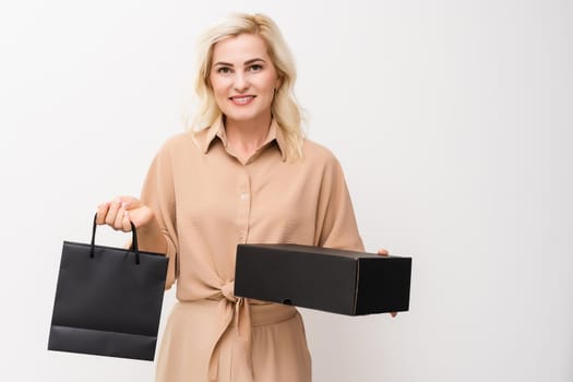 Woman holding blank black craft package, mock-up of black paper bag with handles.