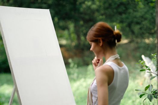 woman outdoors painting a picture easel art hobby. High quality photo