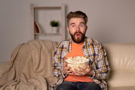 single man on the couch watching TV in a room