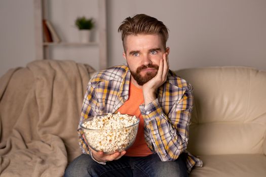 single man on the couch watching TV in a room