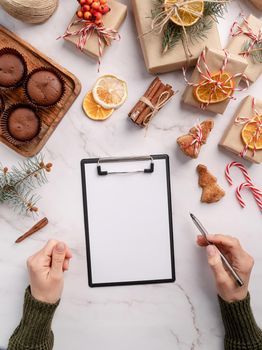 New Year Resolution and Motivation Concept. top view hands writing new year goals, resolution or shopping list on a blank paper. Mock up design