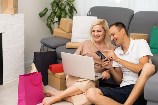 Laughing couple browsing the internet at the laptop.