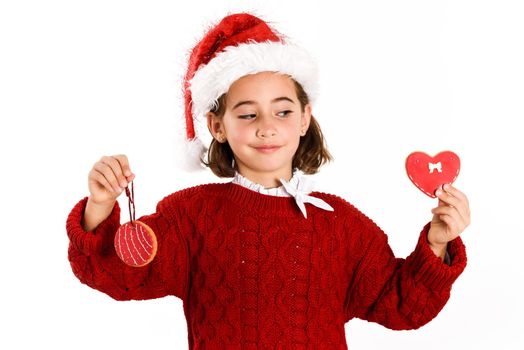 Adorable little girl wearing santa hat with Christmas cookies isolated on white background. Winter clothes