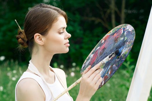 woman artist nature paints palette easel creative landscape. High quality photo