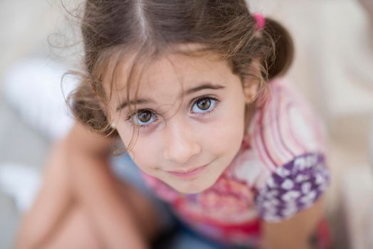 Adorable little girl combed with pigtails outdoors.