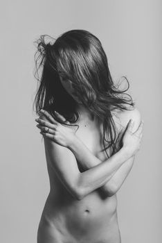 Beautiful naked woman with brown long hair and nice body on white background
