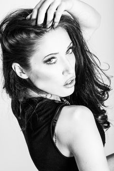 Brunette woman with blue eyes wearing sweater and blue jeans on white background. Studio shoot
