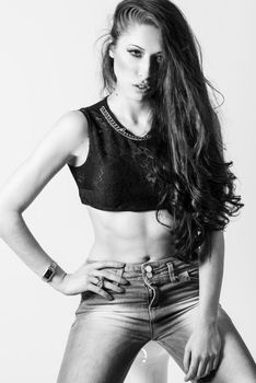 Brunette woman with blue eyes wearing sweater and blue jeans on white background. Studio shoot