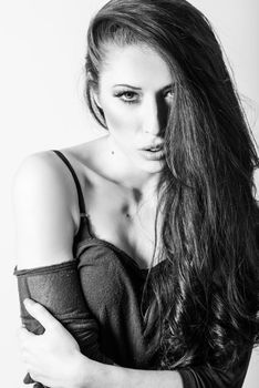 Brunette woman with blue eyes wearing sweater and blue jeans on white background. Studio shoot