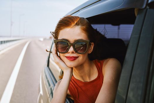 pretty woman in sunglasses rides in a travel car. High quality photo
