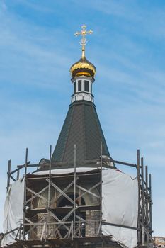 Repair, restoration or construction of a new church in the city against the blue sky.